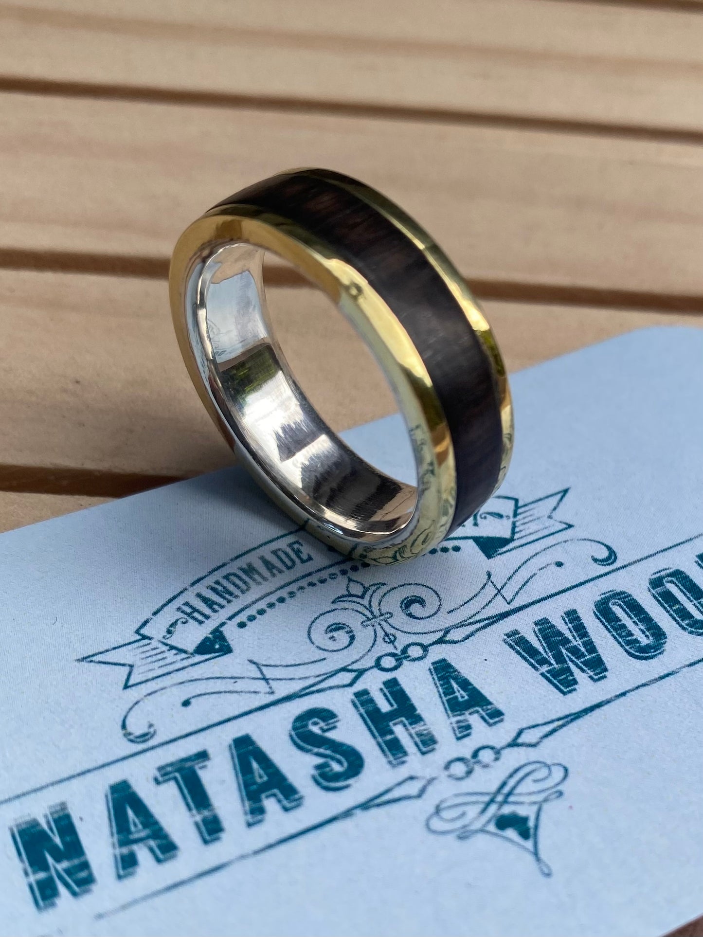 Close-up of the mixed metal and wood ring showcasing the smooth transition between the silver, bronze, and wood materials.