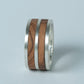 Angled side view highlighting the contrasting layers of wood and silver in the ring